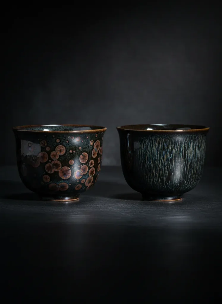Side by side comparison of oil spot Jian Zhan cup with rust oxidation versus hare fur cup in pristine condition