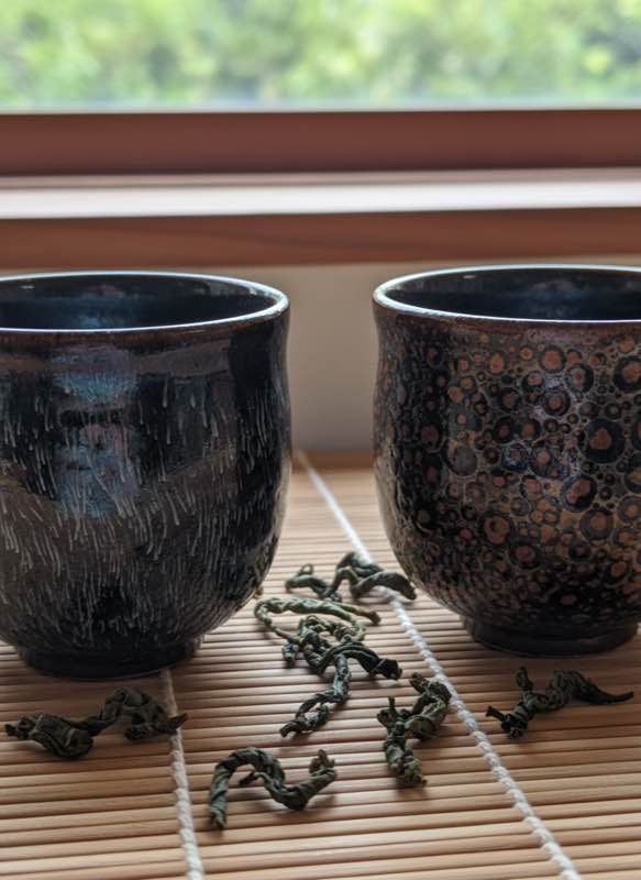 Two dark-glazed tea cups comparison hare's fur and oil spot
