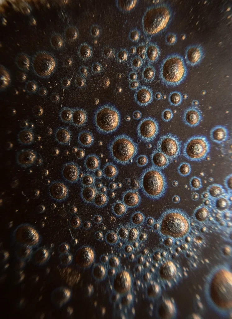 What Does "Oil Drop" Mean in Jianzhan Tenmoku 3 Macro detail of yuteki tenmoku iridescent oil spots with blue-purple halos