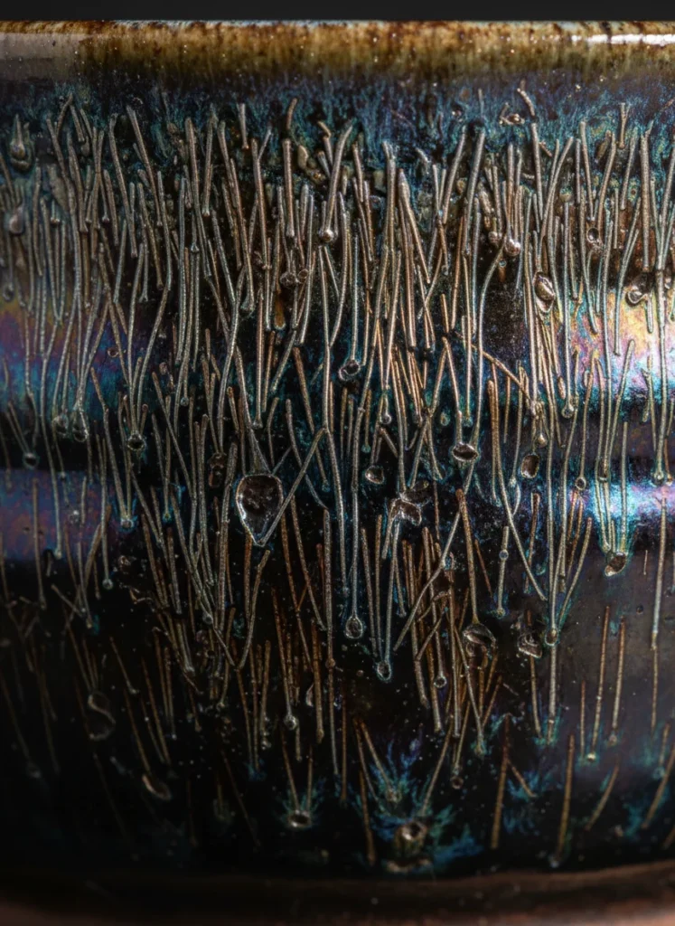 The Meaning of "Rabbit Hair" in Jianzhan Tianmu 3 Macro detail of hare fur tenmoku glaze showing metallic streaks with iridescent halos