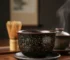 Handmade Jian Zhan tea cup featuring oil spot glaze pattern with golden metallic droplets on dark ceramic surface