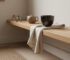 Japandi minimalist tea corner with warm wood shelf and dark handmade ceramic cup