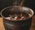 Tenmoku iron glaze tea cup with oolong tea being poured